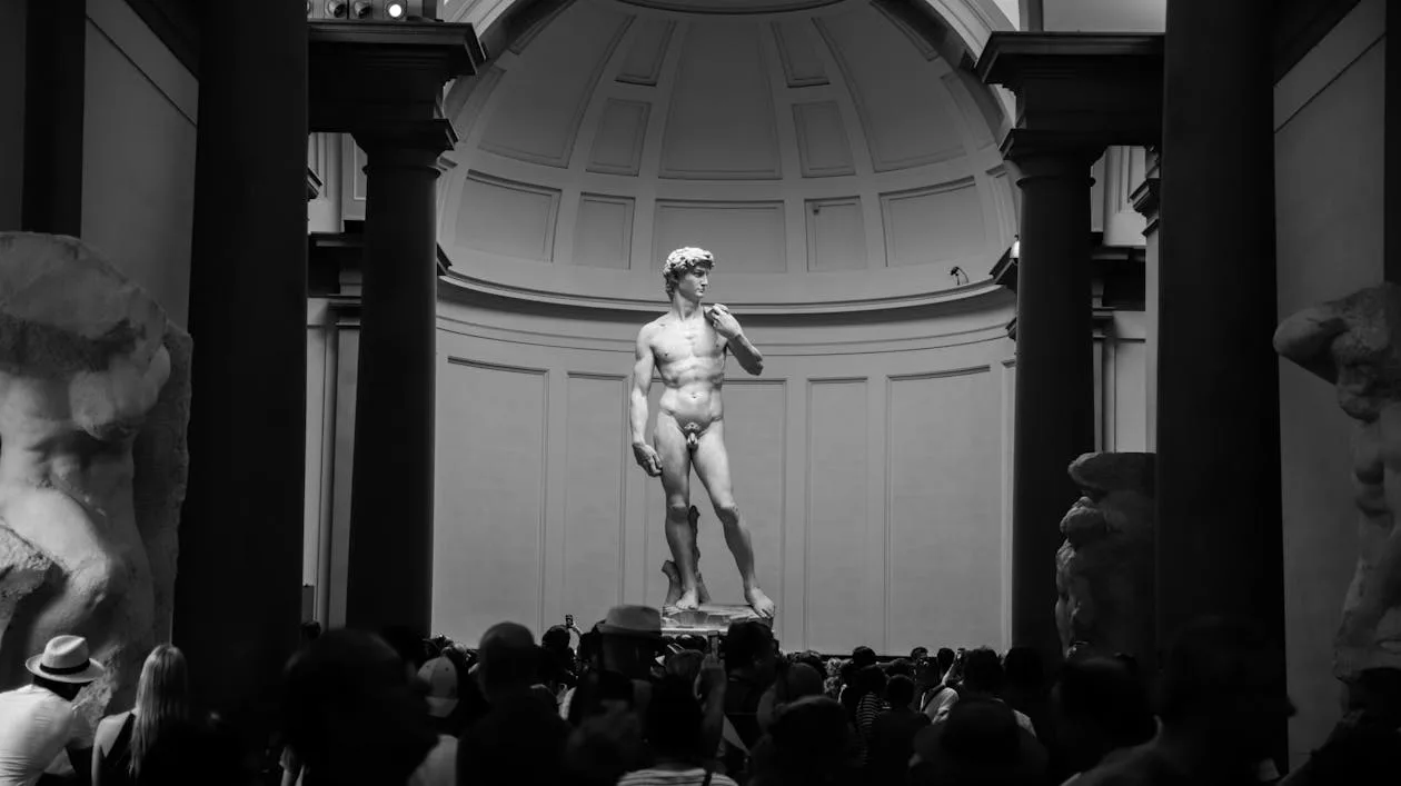 Michelangelo's David in the Tribune room of the Accademia Gallery, Florence — with the Prisoners visible on either side