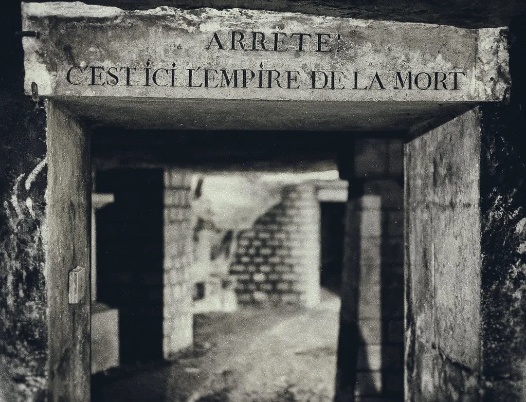 Stone arch with the inscription 'Arrête, c'est ici l'empire de la mort' — Catacombs of Paris ossuary entrance