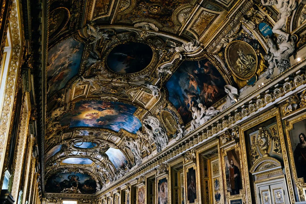 Ornate gold-painted ceiling with baroque paintings in a grand ceremonial hall