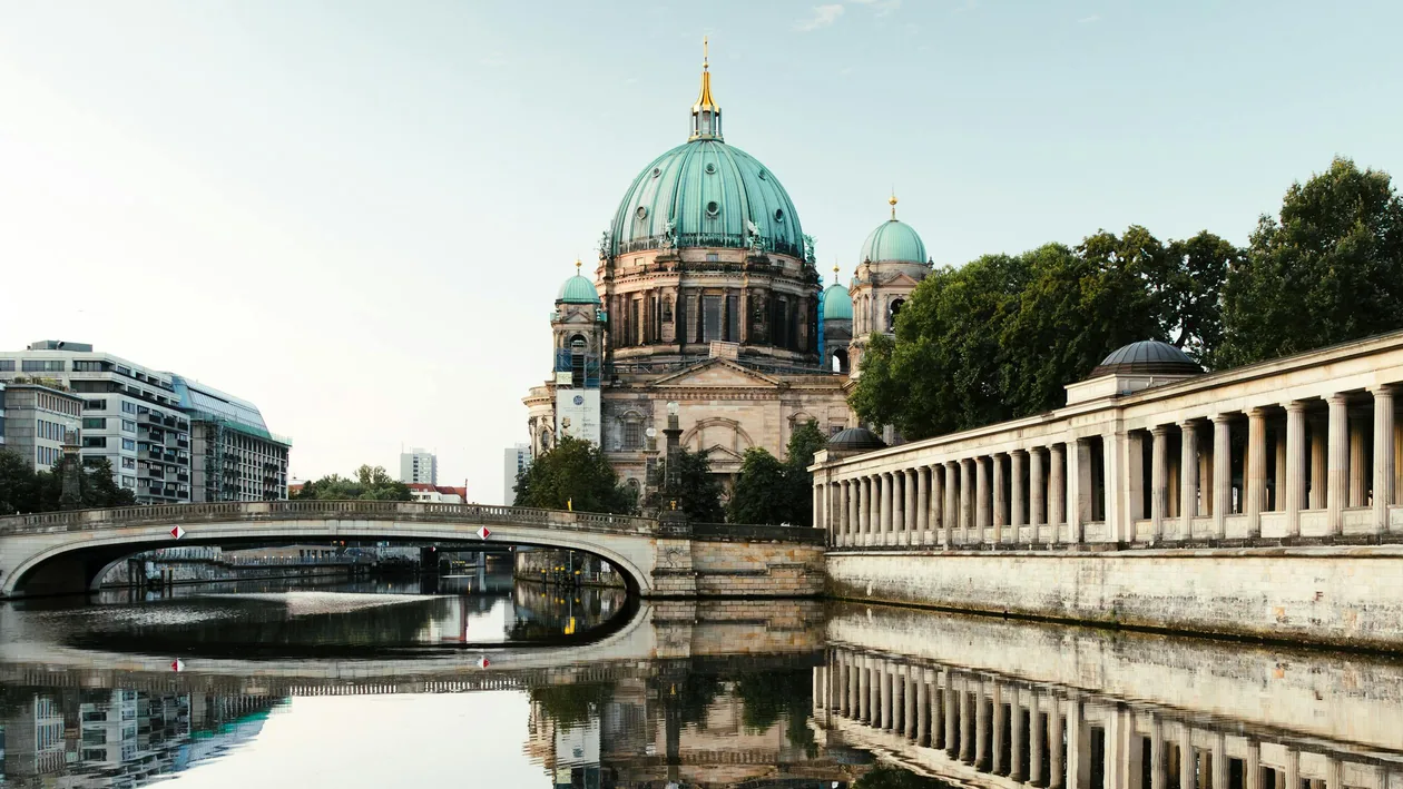 Berliner Dom dome and Kolonnadenhof colonnade reflected in the Spree at sunrise