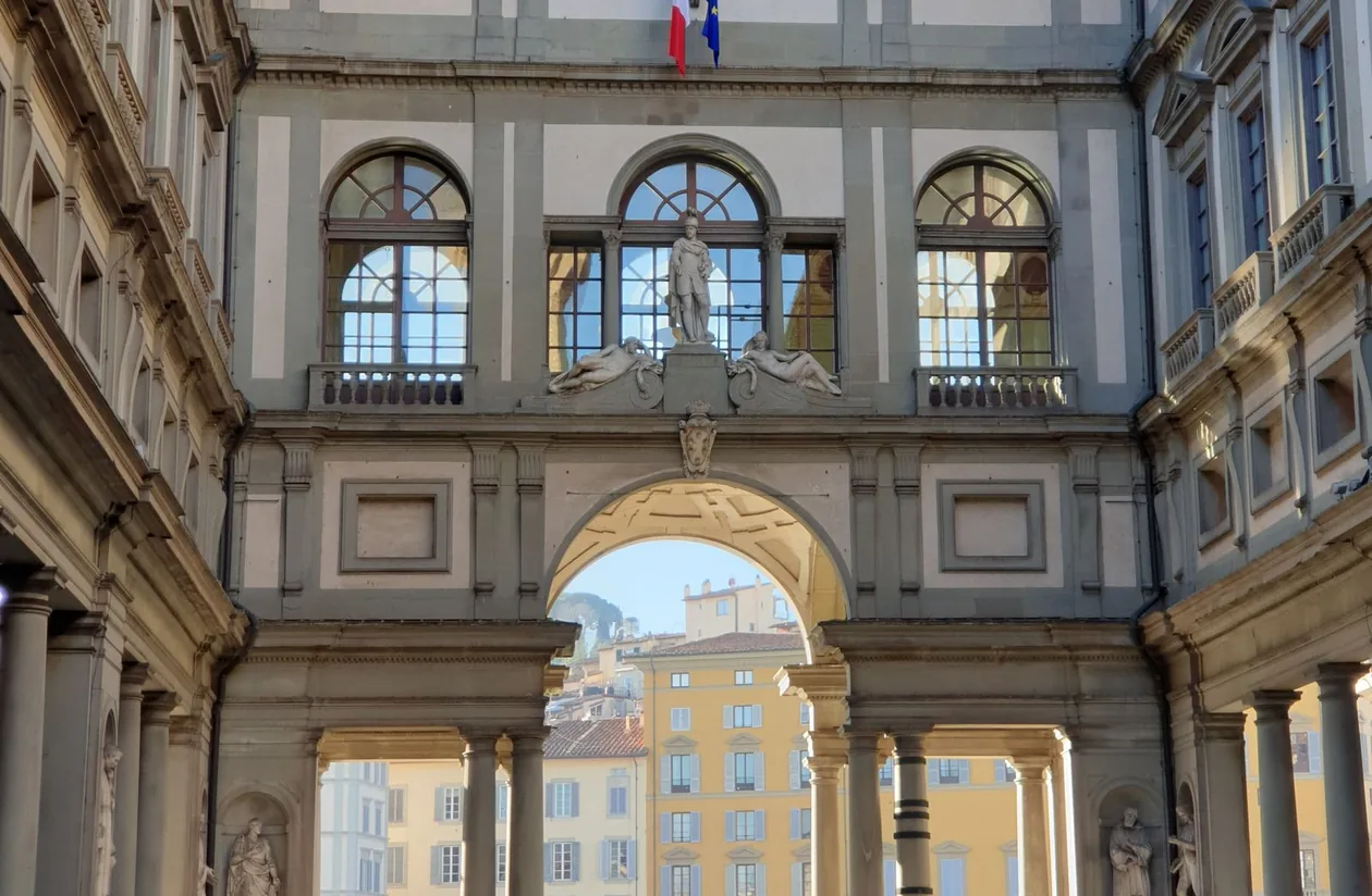 The Uffizi Gallery's long sculpture-lined corridor in Florence with its frescoed ceiling