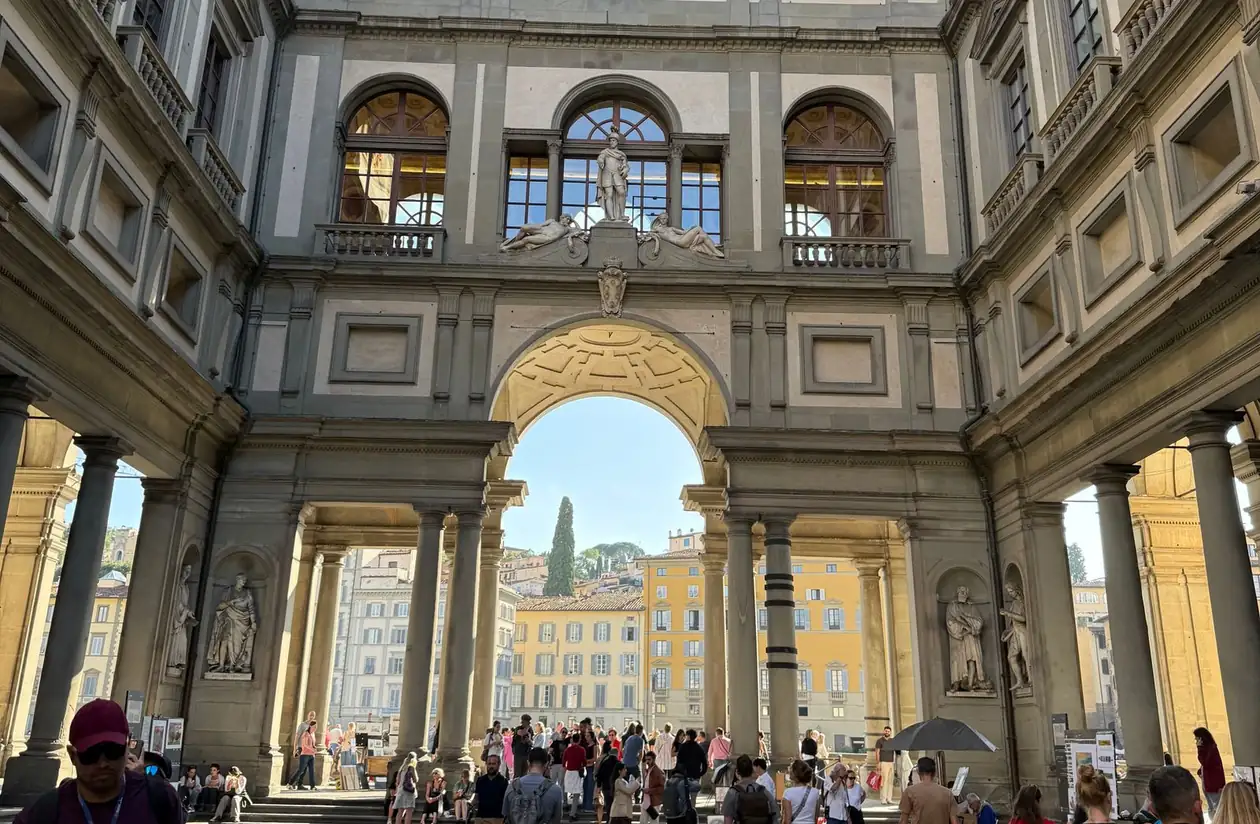 The Uffizi Gallery's sculpture-lined corridor with its frescoed ceiling in Florence